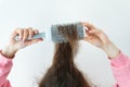 Hair close-up, comb in hand. The girl dries her hair with a comb. The concept of home care, drying healthy hair with a hairdryer Royalty Free Stock Photo