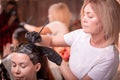 Hair coloring in the salon, hair styling. Professional wizard paints the hair in the salon. Beauty concept, hair care. Royalty Free Stock Photo