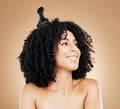 Hair, comb and thinking woman with afro for style  in a studio brown background for wellness and skincare Royalty Free Stock Photo