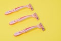 Hair depilation. Pink razors on a colored background. Hair removal from the face and legs. Women`s hygiene