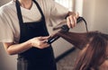 Hair doesnt make the woman, but good hair definitely helps. a hairstylist using a curling iron to do her clients hair.