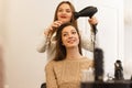 Hair dresser making style for a female client Royalty Free Stock Photo