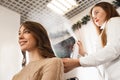 Hair dresser spraying with varnish to client`s hair style Royalty Free Stock Photo