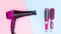Hair dryer and hairbrushes appear on blue pink theme. Stop motion