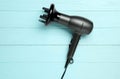 Hair dryer on blue wooden table, top view. Professional hairdresser tool