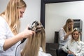 Hair extension for a client by a hairdresser in a beauty salon