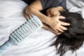 Hair falls out in the comb,Depressed asian woman holding head with her hand from hair loss problem,Stressed female patient