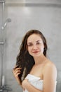 Hair. Girl touching her hair and smiling while looking in the mirror.Portrait of happy young woman with wet hair in bathroom. Royalty Free Stock Photo