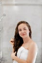 Hair. Girl touching her hair and smiling while looking in the mirror.Portrait of happy young woman with wet hair in bathroom. Royalty Free Stock Photo