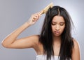 Hair, knot and woman with brush in studio with worry for split ends, haircare crisis and messy style. Beauty