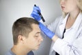 A trichologist examines the hair of a man who begins alopecia. Consultation with a dermatologist. Hair loss, alopecia, pruritus,