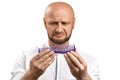 Hair loss concept. Young bald man with a hairbrush on a white background. Royalty Free Stock Photo