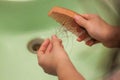 Hair loss and hair care. Hands holding a comb and hair. The girl is combing her hair in the bathroom and a lot of hair fell out Royalty Free Stock Photo