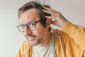 Hair loss, man looking at the mirror concerned about losing his hair at forehead Royalty Free Stock Photo