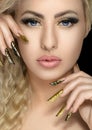 Hair and make-up theme: beautiful girl with beautiful golden nail in the studio