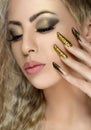 Hair and make-up theme: beautiful girl with beautiful golden nail in the studio