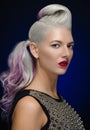 Hair and make-up theme: beautiful young blond woman with creative hair styling with red lips on a dark blue background in studio Royalty Free Stock Photo