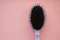 Hair massage comb brush with handle for all types  on pink pastel copy space background. Minimalistic flat lay. Royalty Free Stock Photo