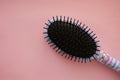 Hair massage comb brush with handle for all types  on pink pastel copy space background. Minimalistic flat lay. Royalty Free Stock Photo