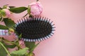 Hair massage comb brush with peony flowers  on pink pastel copy space background. Minimalistic flat lay. Royalty Free Stock Photo