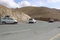 A hair pin bend at kargil circular road with tourist cars and mountain background