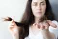 Hair problem. A blurry portrait of a sad woman showing a close-up of a fallen bunch of hair on the palm of her hand. The