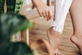 Hair Removal concept, depilation process. Young woman in white towel applying shaving cream on her legs and holding holding Royalty Free Stock Photo