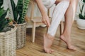 Hair Removal concept, depilation process. Young woman in white towel applying shaving cream on her legs and holding holding Royalty Free Stock Photo