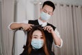 Hair salon concept both male hairstylist and female customer wearing a protective face masks during haircut process Royalty Free Stock Photo