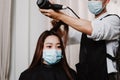 Hair salon concept a male hairstylist using a comb to grab a lock of hair and using hair dryer for drying and straightening