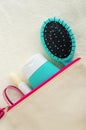 Hair shampoo mask, conditioner, face cream, sunscreen lotion and hair brush in the small make-up pouch. Top view, copy space