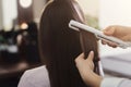 Hair straightening by a hairdresser in a professional salon,