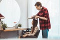 Hair stylist barber styling long hair with brush for beautiful asian young woman in beauty salon working moment Royalty Free Stock Photo