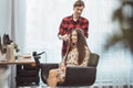 Hair stylist barber styling long hair with hair iron for beautiful young woman in beauty salon working moment Royalty Free Stock Photo