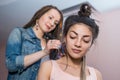 A hair stylist combs hair to make Zizi cornrows