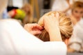 Hair stylist& x27;s hands doing professional hairstyling of female long hair in a beauty salon.