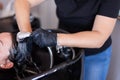 Hair stylist washing woman hair in salon. Selective focus. Royalty Free Stock Photo
