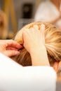 Hair stylist& x27;s hands doing professional hairstyling of female long hair in a beauty salon.