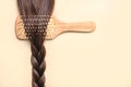 Hairbrush with female brown hair braid.Hairdresser salon and hairstyles concept Royalty Free Stock Photo