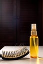 Hairbrush with hairs and hair loss remedy on table, cure of loss hair alternative medicine concept