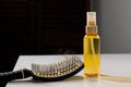 Hairbrush with hairs and hair loss remedy on table, cure of loss hair alternative medicine concept