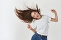 Haircare and beauty concept. Happy young woman dancing and whip healthy shiny hair, having fun, standing joyful over Royalty Free Stock Photo