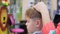 Haircut of a child with scissors in the barbershop