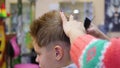 Haircut of a child with scissors in the barbershop