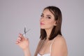 Haircut. Portrait of young woman hairdresser cutting hair with scissors. Girl with beautiful hair look at scissors Royalty Free Stock Photo