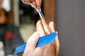 Haircut of red hair tips with comb and scissors by hands of a male hairdresser in a hair salon, close up. Royalty Free Stock Photo