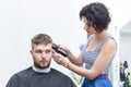 Haircuts a young guy in a hairdresser.