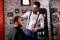 Hairdresser adjusts hair a customer with a comb Royalty Free Stock Photo