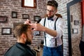 Hairdresser adjusts hair a customer with a comb Royalty Free Stock Photo