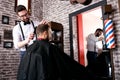 Hairdresser adjusts hair a customer with a comb Royalty Free Stock Photo